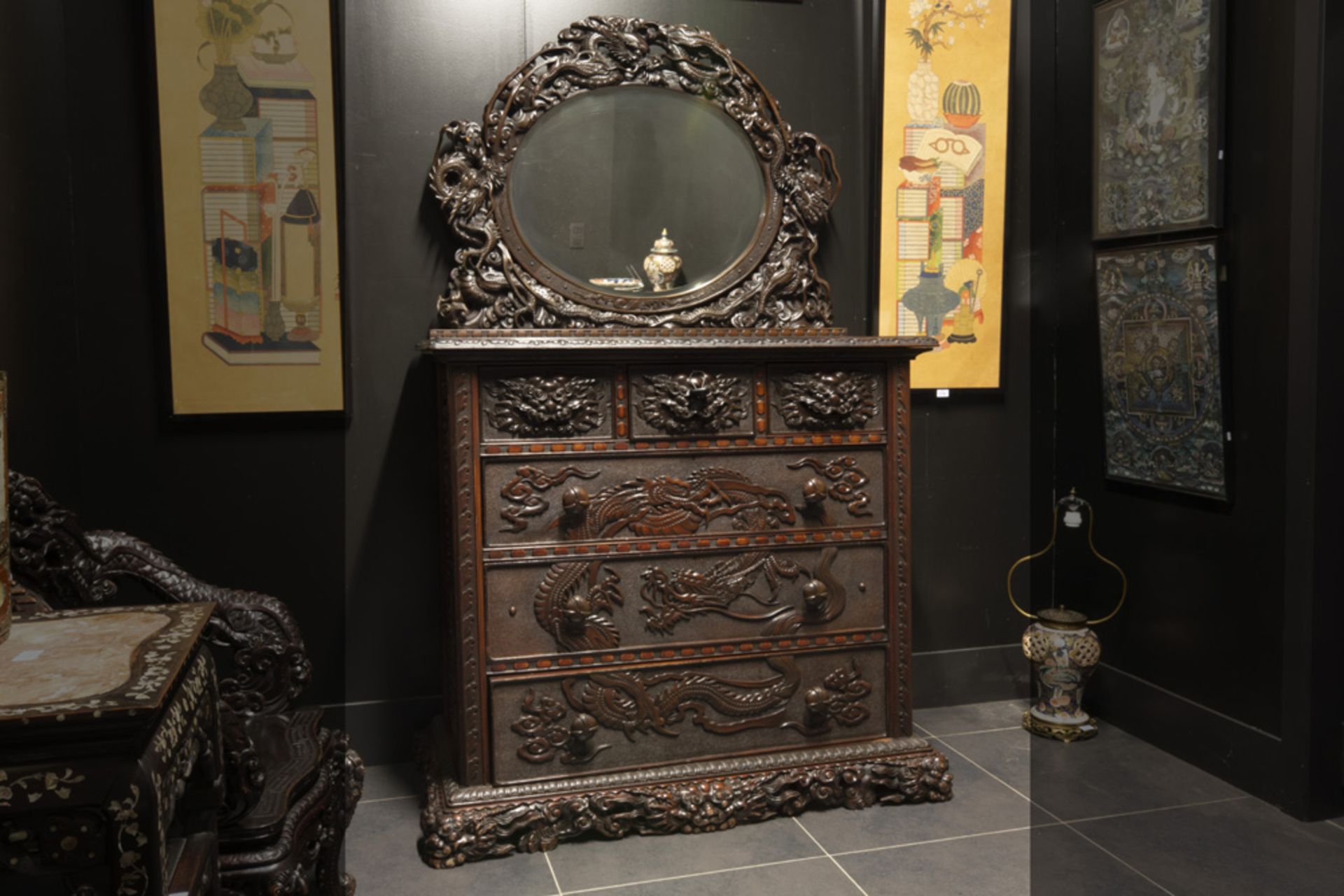 antique Chinese coiffeuse/chest of drawers with top with mirror in richly sculpted (rose- ?) wood ||