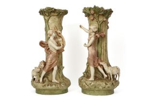 pair of 'antique' vases (each with a figure) in Royal Dux marked porcelain || Paar vazen van ca 1900