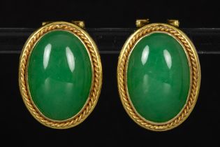 pair of earrings in yellow gold (18 carat) each with a green stone (maybe Jade) cabochon || Paar