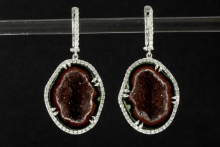 pair of trendy earrings in white gold (18 carat), each with a half geode of white and rust colored