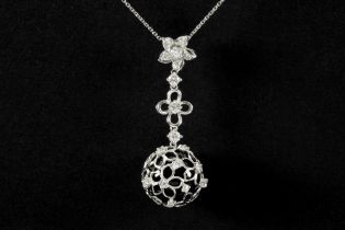beautiful pendant in white gold (18 carat) with a ball of black onyx, contained in a golden grid,