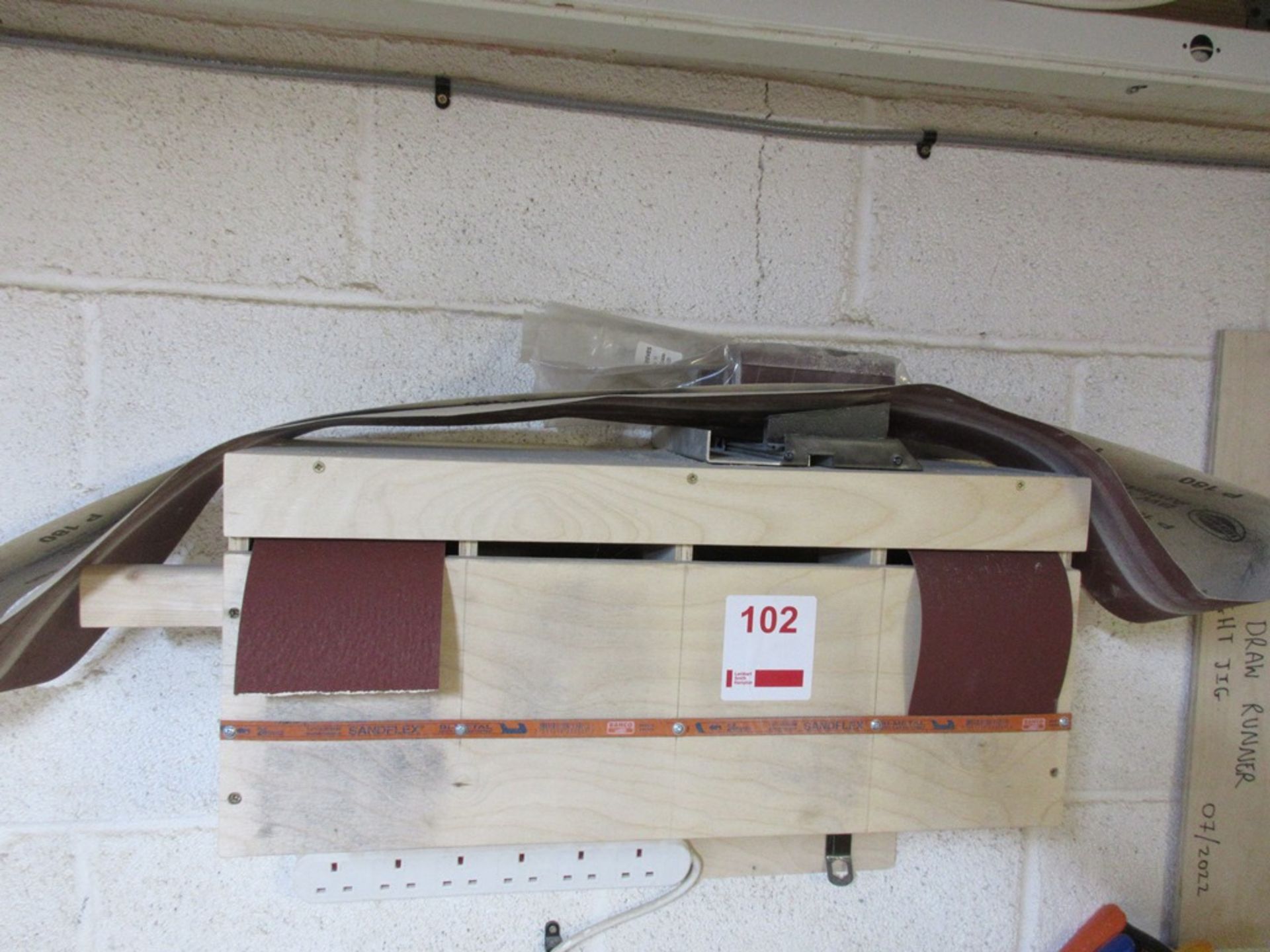 Bespoke sand paper dispenser with contents of cupboard including assorted sand paper and bespoke