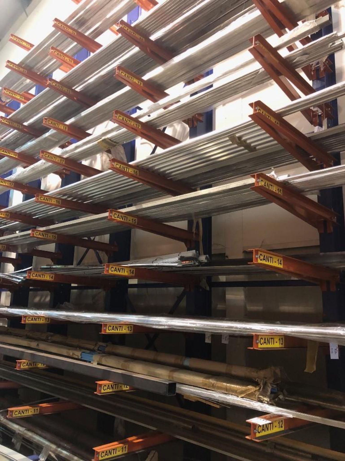 4 bays of heavy duty cantilever racking consisting of 5 L shaped blue frame upright beams 6m tall