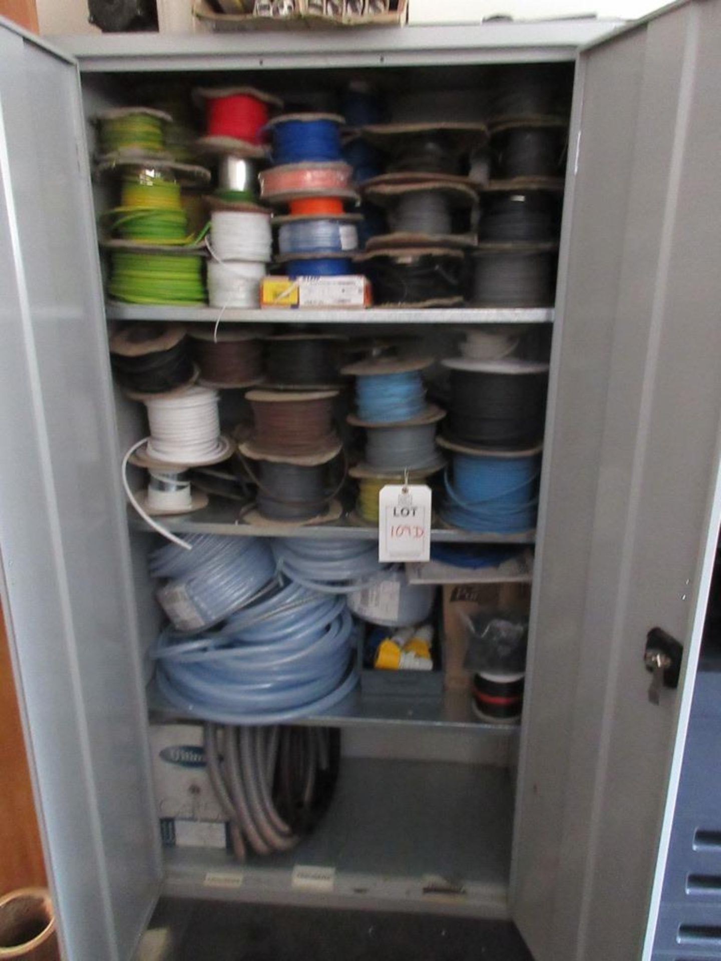 Cupboard and contents including various reeled electrical cable, hosing, etc.