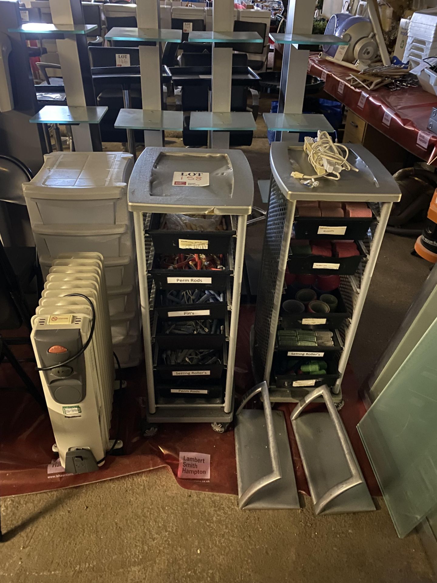 Two metal framed hairdressing trollies, one plastic upright storage trolley, one electric radiator