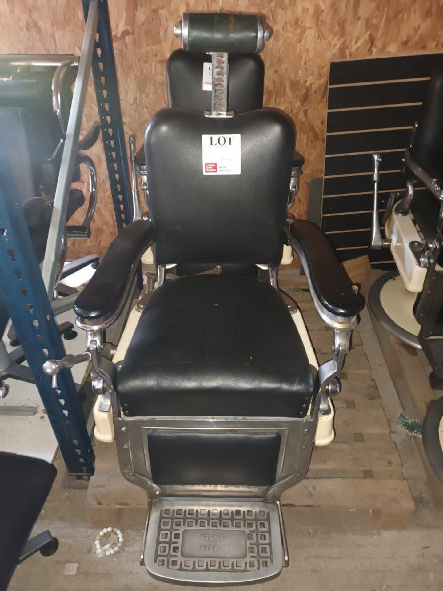 Black leather upholstered hydraulic salon chair with head rest