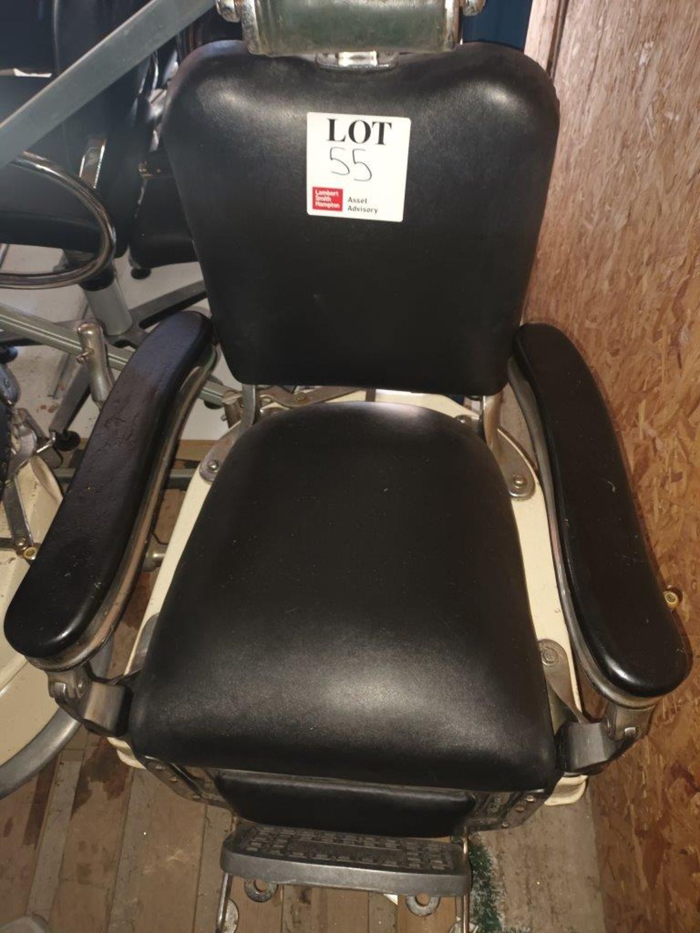 Black leather upholstered hydraulic salon chair with head rest