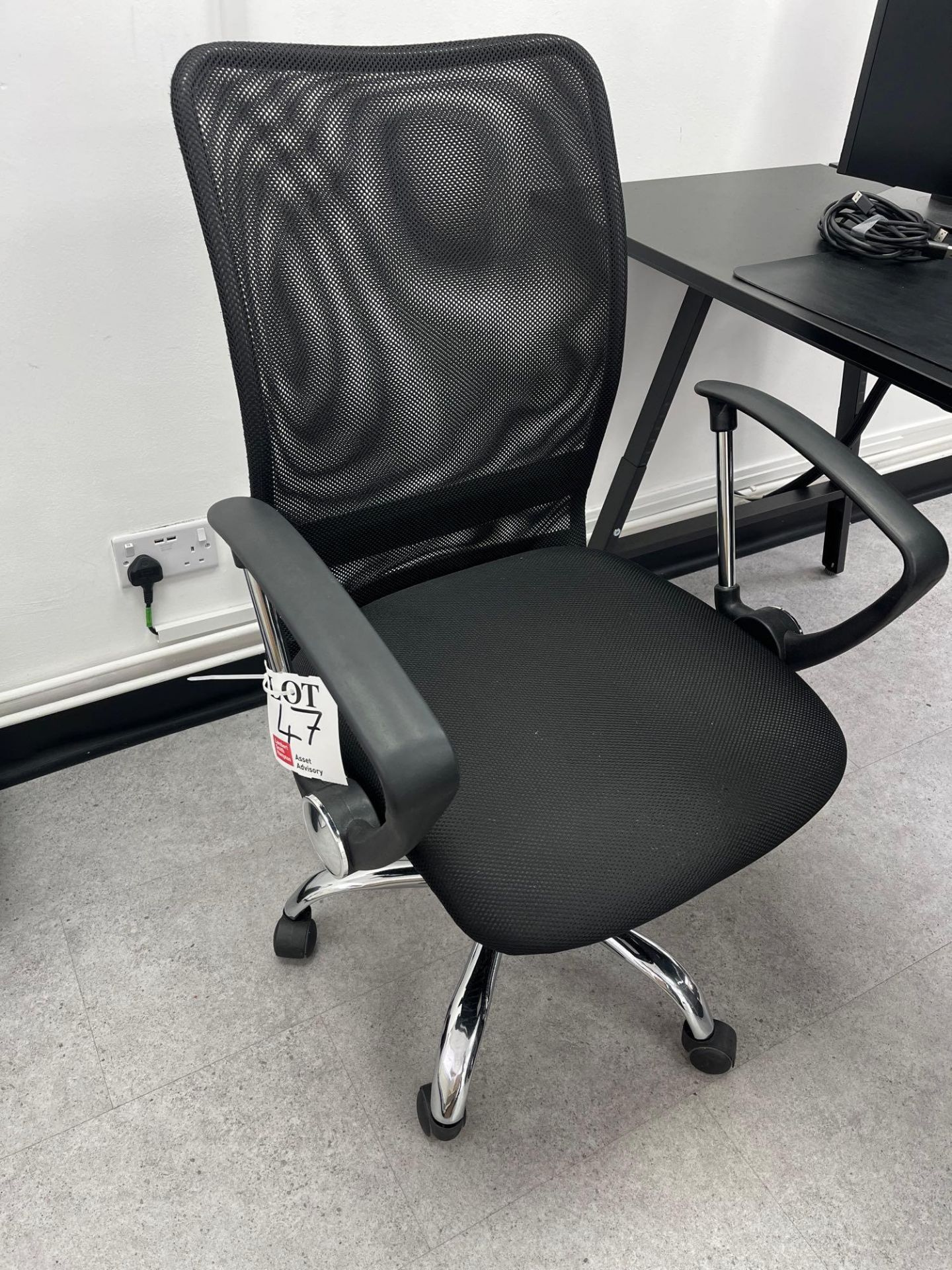 Four black mesh back swivel office chairs