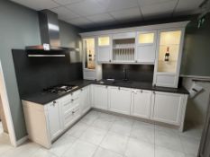 Cream and dark stone effect L shaped display kitchen to include blanco sink.