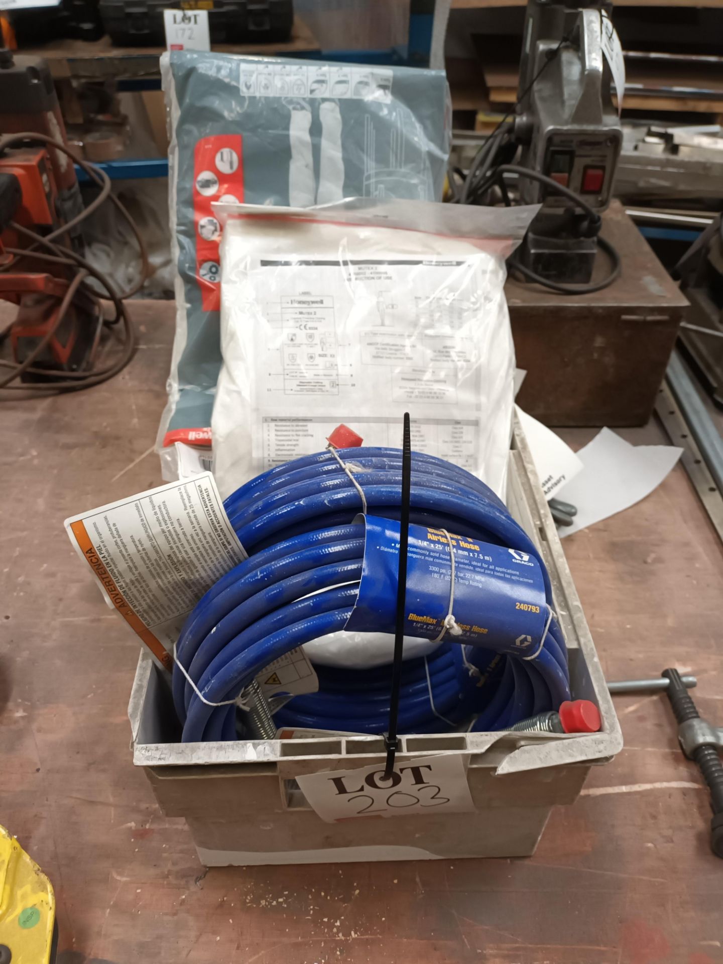 Two BlueMax II airless hoses with various protective overalls