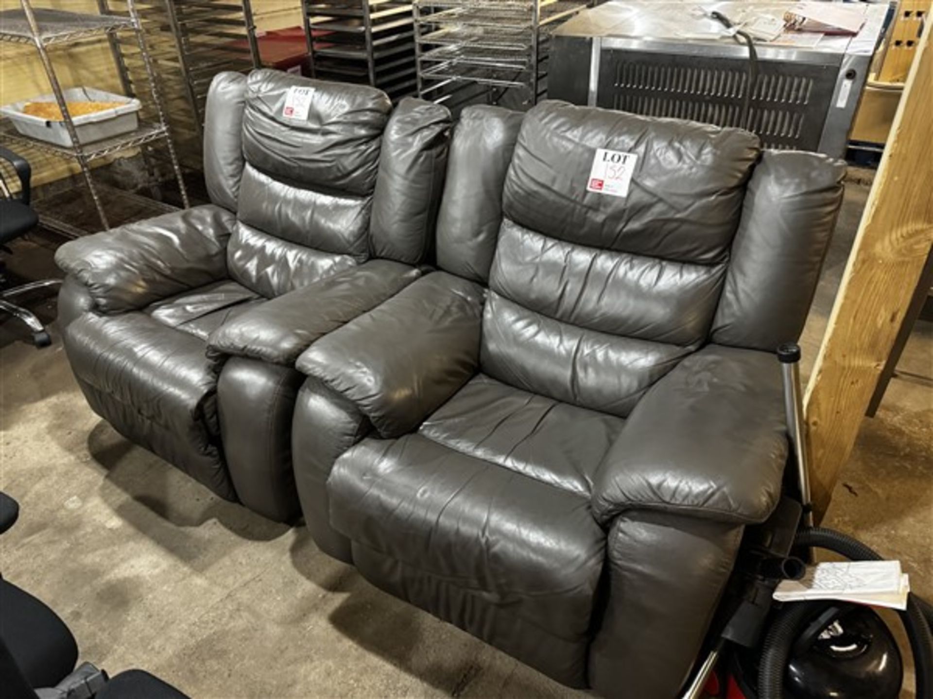 Two charcoal leather effect reclining armchairs