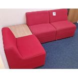 Three red upholstered waiting room chairs, with table