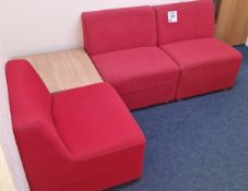 Three red upholstered waiting room chairs, with table