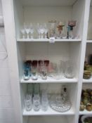 3x shelves of various clear and coloured glassware