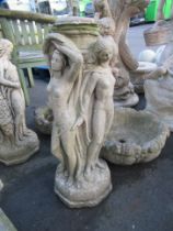 A Bird Bath adorned with 3 Ladies