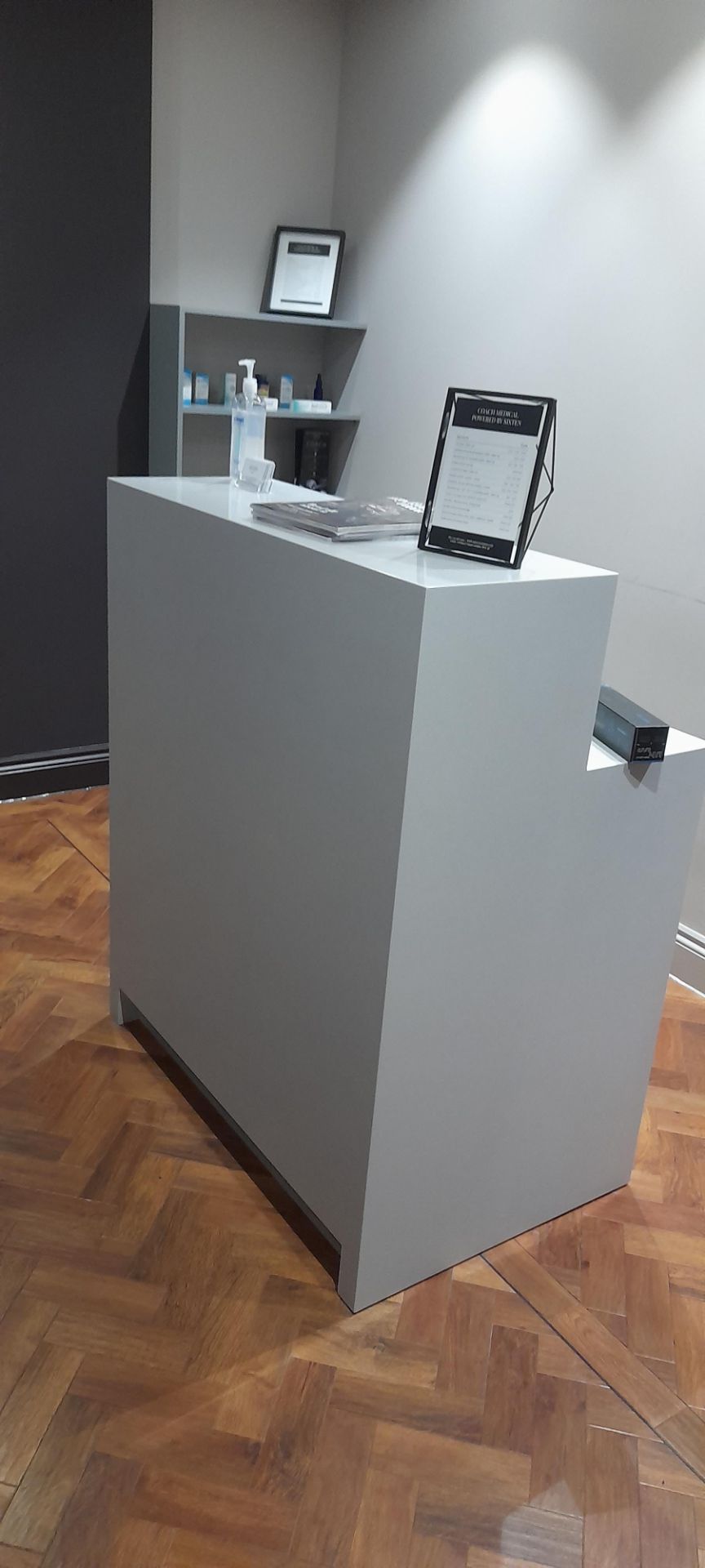 Freestanding reception desk with cupboard under, approx. 1m wide. Contents excluded