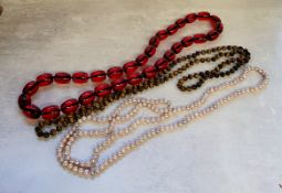 A blush pink cultured pearl 23" necklace; a tigers eye bead 22" necklace; a cherry 'amber' large