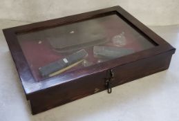 A bijouterie cabinet with contents including cut throat razors, ceramic boots, etc