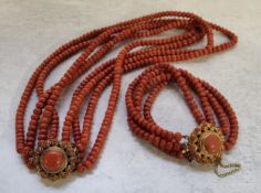 A Dutch four strand coral necklace, the circular clasp mounted with a central round coral stone with