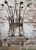 A substantial 19th century hand forged wrought iron twelve branch chandelier, depicting rams