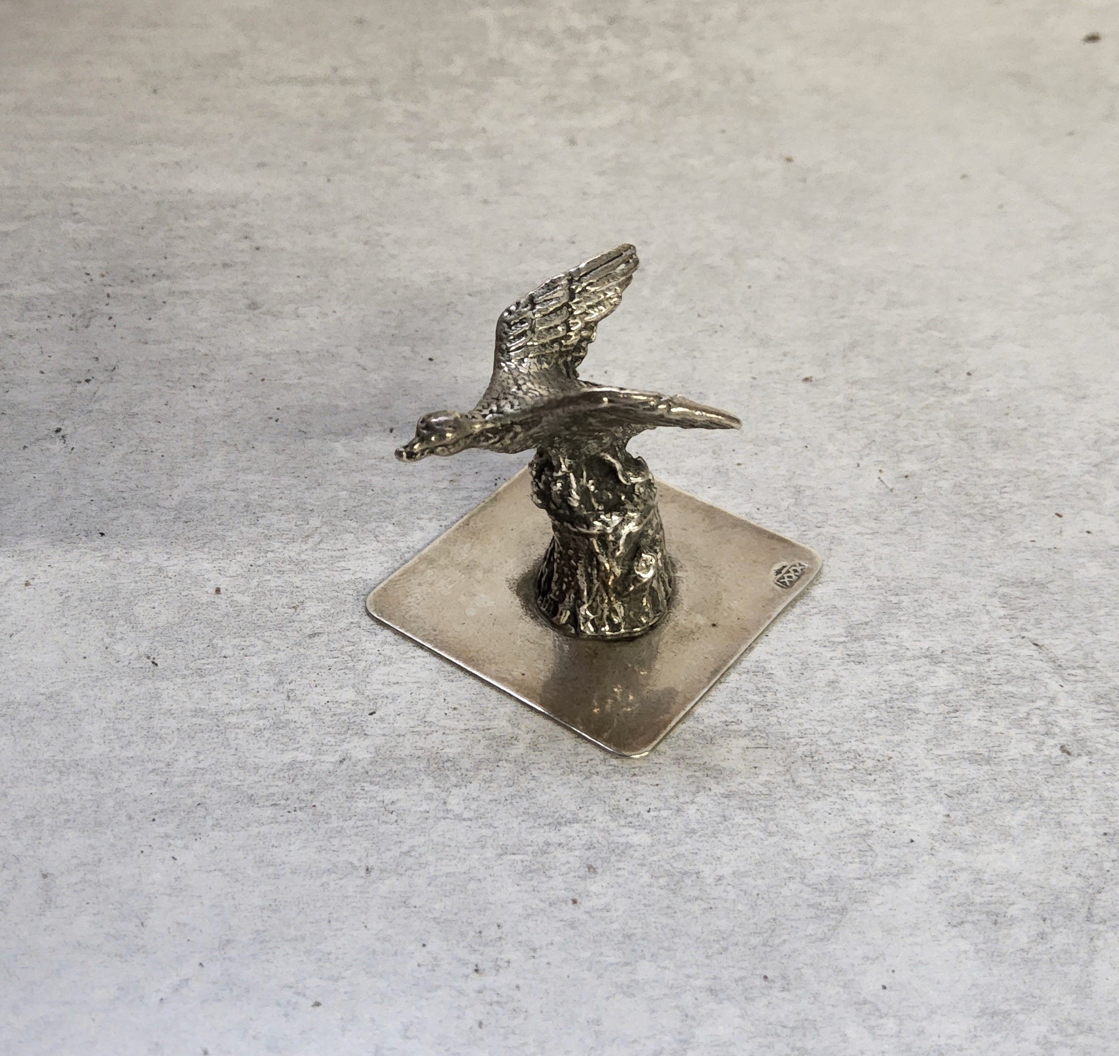 A Dutch silver model of a duck in flight over a tree stump, stamped XXX, 22.89g