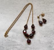 An 18ct gold & garnet drop necklace, mounted with seven Pear shaped garnets, stamped 750; a pair