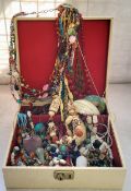 A vintage jewellery box containing various necklaces including a carved alabaster necklace with an