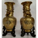 A pair of Chinese bronze slender necked temple vases, cast in relief with a dragon, chased