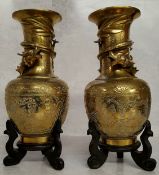 A pair of Chinese bronze slender necked temple vases, cast in relief with a dragon, chased