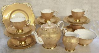 An Art Deco Tuscan tea service for six, decorated with an intricate gold filigree pattern on a white