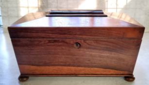 A William IV rosewood tea caddy, of sarcophagus form, the hinged cover enclosing a pair of lidded