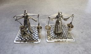 A Dutch silver figures of a male & female milk carrier in traditional dress on a base decorated in