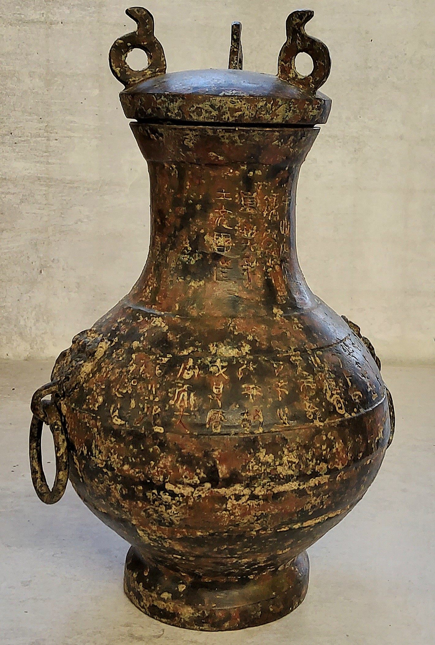 Chinese bronze archaic style temple vase with loop handles, the body engraved throughout with script