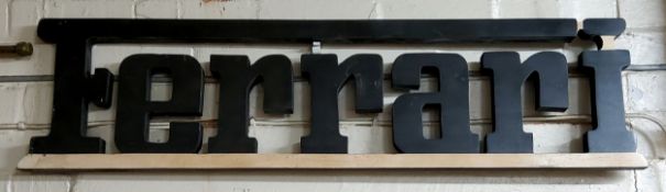 Advertising - a Ferrari wooden wall hanging sign, the letters painted black 112cms x 28cms high