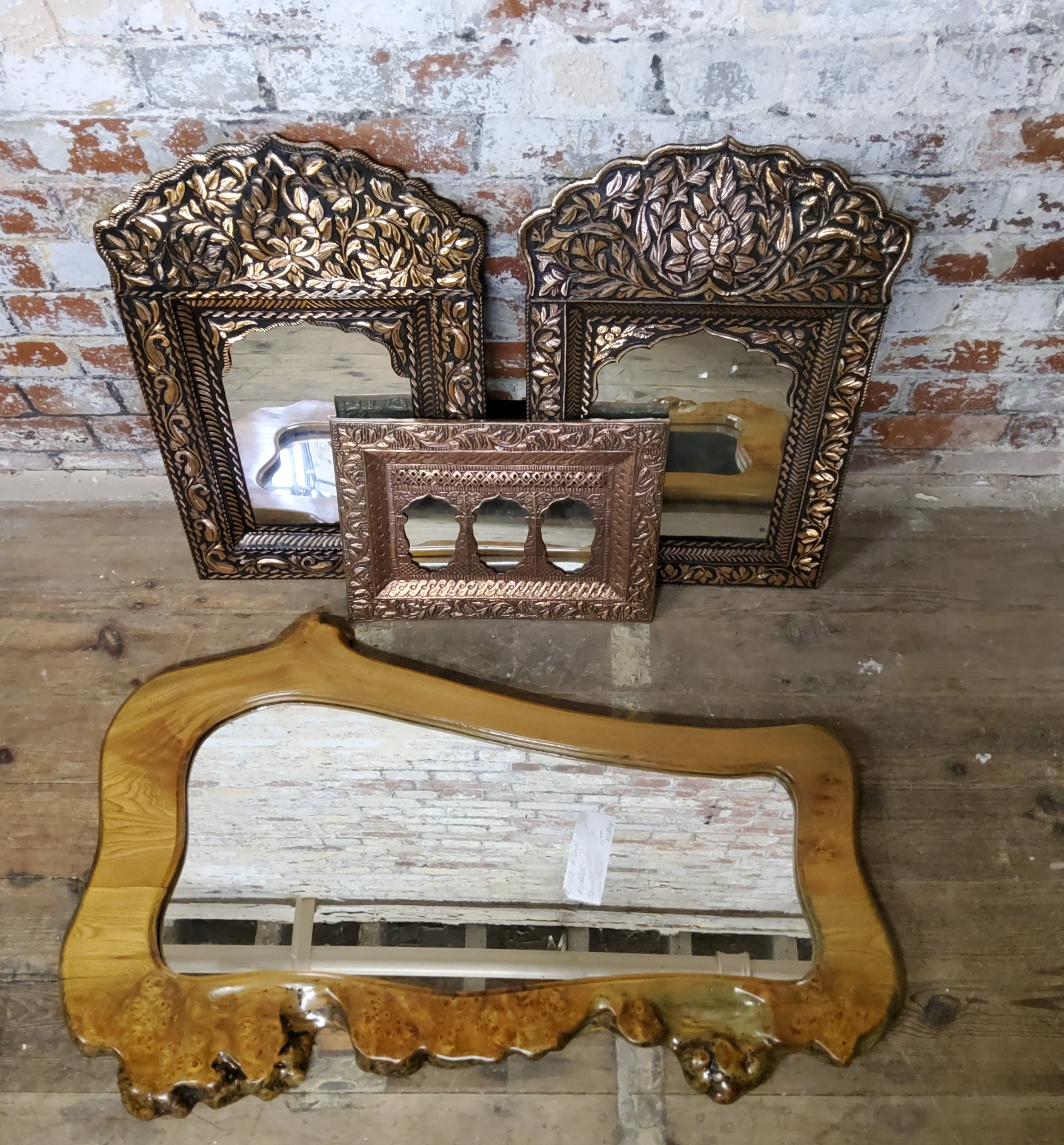 A mid century Burr naturally shaped 'live edge' wall mirror; a pair of Indian decor inspired pressed