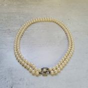 A Mikimoto two strand cultured pearl necklace, silver clasp, mounted with a single pearl, stamped