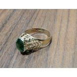 A vintage 9ct gold dress ring. set with an oval green stone, pierce worked shoulders, London,