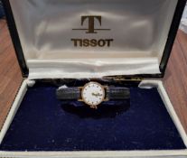 An 18ct gold lady's Tissot watch, Swiss movment, silver dial, gold & black batons, later black