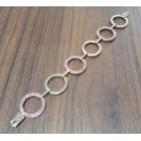 A contemporary 9ct gold fancy link bracelet, each alternate circular link set with round pink