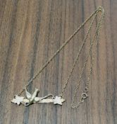 A 9ct gold pendant necklace, the pendant bar mounted with a swallow and foilage, belcher chain 2.85g