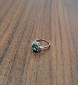 A 14ct gold dress halo ring set with central oval green stone surrounded by two rows of round
