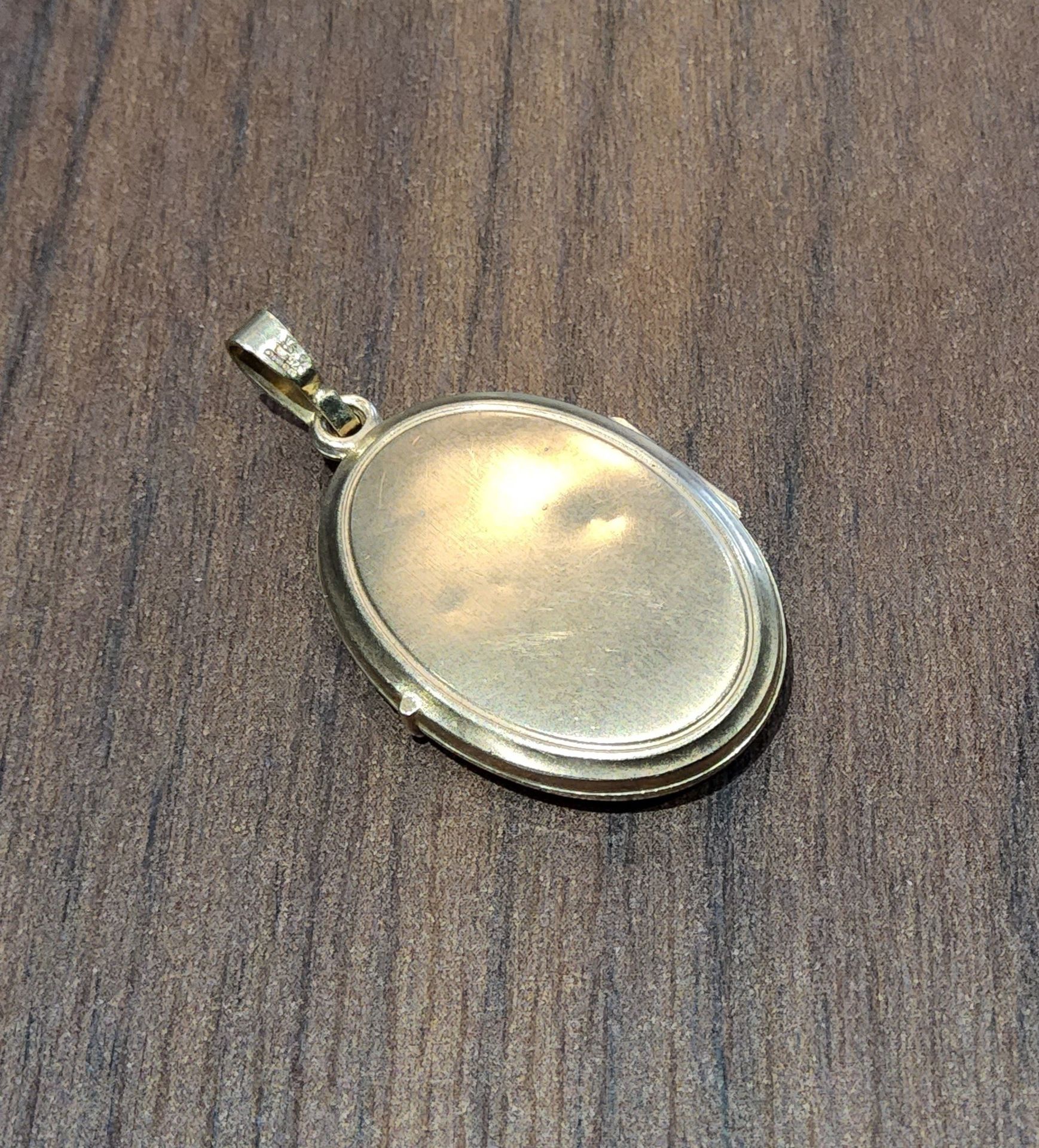 A 9ct gold oval locket, scroll decoration to front, 3.24g gross - Image 2 of 2