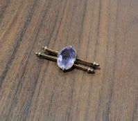 A 9ct gold two bar brooch, centrally set with an oval amethyst (16 x 12mm), stamped 9ct, 4.1g gross