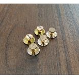 A set of five 9ct gold studs, two with enamel decoration, three with a machined chequer board design