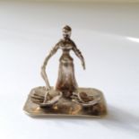 A late 19th century Dutch silver miniature of a female fish seller and her wares, stamped Dutch