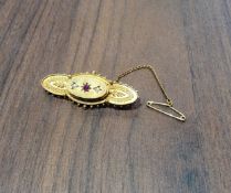 A Victorian 15ct gold bar brooch, set with a central ruby and seed pearls, 4.5cms 4.27g gross