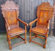 A pair of country house Wainscot type hall chairs, profusely carved head rest with bold lozenge