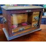 An early 20th century oak stationery box, the hinged top releases the glazed fall front revealing