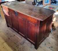 An 18th century vernacular oak Welsh coffer with four cross banded fielded panels raised on stile