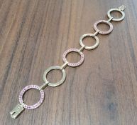 A contemporary 9ct gold fancy link bracelet, each alternate circular link set with round pink